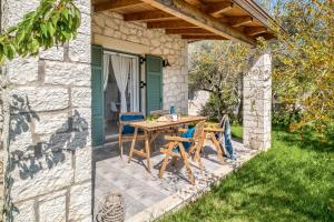 a table and chairs on a patio outside of a stone house at Apanema Mindfulness Resort Lefkada - ultra fast Starlink WiFi in 2025 in Asprogerakata