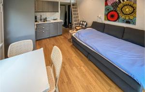 a bedroom with a bed and a table and chairs at 1 Bedroom Stunning Home In Grimsholmen in Grimsholmen