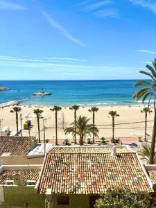 a view of a beach with palm trees and the ocean at Old Town Blue Suite in Villajoyosa