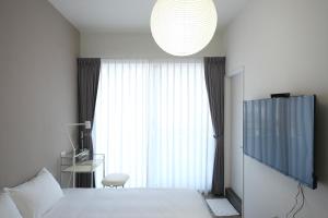 a bedroom with a bed and a large window at 衛民居 wei min stay in Tainan