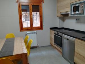 a kitchen with a table and a stove top oven at Casa Quini in Biescas