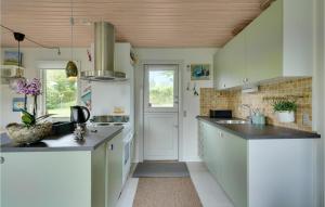 a kitchen with white cabinets and black counter tops at Beautiful Home In Haarby With Kitchen in Brunshuse
