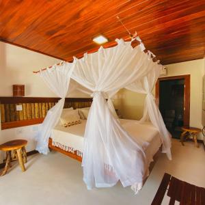 a bedroom with a bed with a canopy at Velho Chico in Icaraí +52 photos