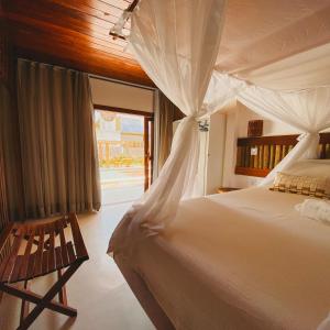 a bedroom with a white bed and a window at Velho Chico in Icaraí