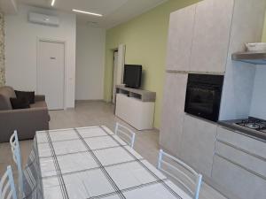 a kitchen and living room with a table and a couch at La Suite in Civitanova Marche