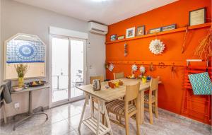 a dining room with orange walls and a table and chairs at Beautiful Apartment In Santa Pola in Santa Pola