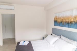 a bedroom with a white bed and a painting on the wall at Bagheria Home in Bagheria