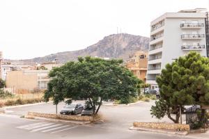 a parking lot with two trees and a building at Bagheria Home in Bagheria