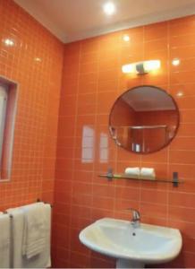 an orange tiled bathroom with a sink and a mirror at Praia da Areia Branca, Lourinhã - Vila Mar Casal dos Patos in Praia da Areia Branca +12 photos
