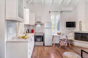 a kitchen with white appliances and a table and chairs at Apanema Mindfulness Resort Lefkada - ultra fast Starlink WiFi in 2025 in Asprogerakata