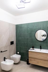 a bathroom with a toilet and a sink and a mirror at Bagheria Home in Bagheria