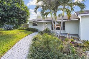 una casa con palmeras y una pasarela en Beach Retreat Downtown Hot Tub, en Delray Beach