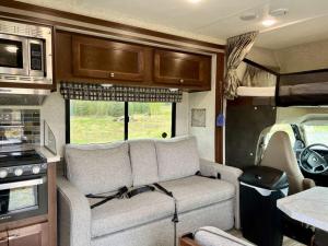 an interior of an rv with a couch and a kitchen at The Glamper at Red-Bow in Sterling