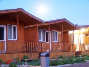 a wooden house with a porch and a fence at Venüs Gold Bungalov Adrasan in Kumluca