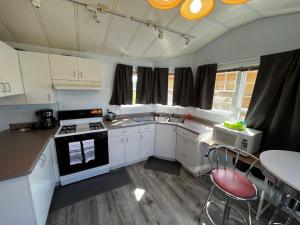 a kitchen with white cabinets and a stove top oven at Trout House at Red-Bow in Sterling