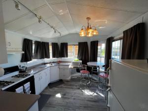 una cucina con mobili bianchi, tavolo e sedie di Trout House at Red-Bow a Sterling