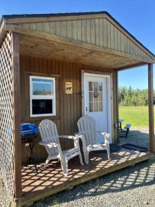 una tettoia con due sedie, un tavolo e una griglia di Grayling Bunkhouse at Red-Bow a Sterling