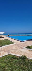 ein Swimmingpool mit dem Meer im Hintergrund in der Unterkunft Serene Escape Villa Ideal for family time and perfect for North Coast getaways in Dawwār Abū Maḩrūs
