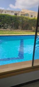 ein großer blauer Pool in einem Haus in der Unterkunft Serene Escape Villa Ideal for family time and perfect for North Coast getaways in Dawwār Abū Maḩrūs