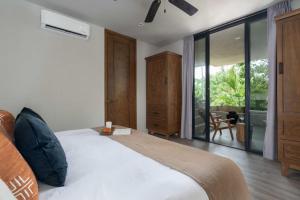 een slaapkamer met een bed en een glazen schuifdeur bij Arthouse Tulum Iconic Apartment Beach Club Access in Tulum +24 foto's