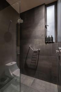 een badkamer met een glazen douche met toilet bij Arthouse Tulum Iconic Apartment Beach Club Access in Tulum