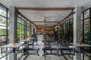 een restaurant met tafels, stoelen en ramen bij Arthouse Tulum Iconic Apartment Beach Club Access in Tulum