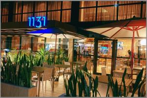 a restaurant with tables and chairs and umbrellas at Hotel Mana&iacute;ra in Jo&atilde;o Pessoa