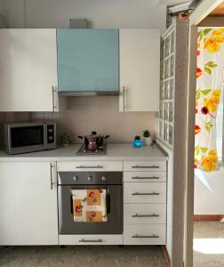 una cocina con estufa y microondas en Appartamento centralissimo zona terme, en Margherita di Savoia