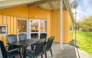 a table and chairs on the porch of a house at Holiday Home Spurvestræde in Dannemare
