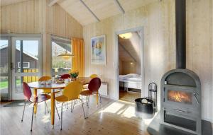a dining room with a table and a wood stove at Holiday Home Spurvestræde in Dannemare
