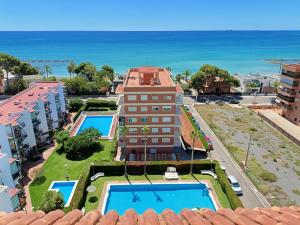 a building with a pool and the ocean in the background at Costa Brazil Sunset Apartment in Benicàssim