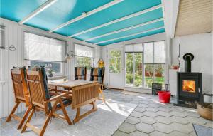 una sala da pranzo con tavolo, sedie e camino di Holiday Home Svalevej Brenderup Fyn Iv a Skovs-Højrup