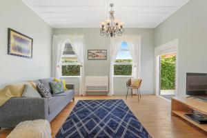 ein Wohnzimmer mit Sofa und Fernseher in der Unterkunft Central Heritage Villa in Rotorua