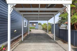 ein blaues Haus mit einer weißen Pergola in der Unterkunft Central Heritage Villa in Rotorua