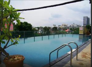 a large swimming pool with blue water in a city at Royal Orchid Central, Pune in Pune