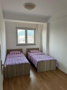 zwei Betten in einem Zimmer mit zwei Fenstern in der Unterkunft Aleksandra in Ohrid
