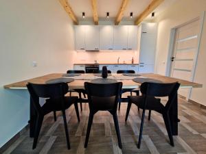 a kitchen with a large wooden table and chairs at AMBER LOFT 19 Rusnė Harbour in Rusnė