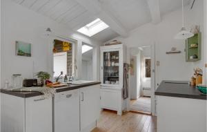 a kitchen with white cabinets and a skylight at Amazing Home In Rørvig With Kitchen in Rørvig