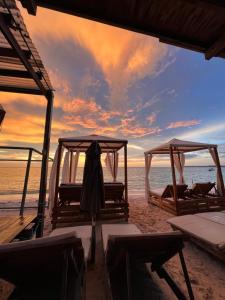 a couple of beds on the beach at sunset at Roma apartamento in Playa Blanca