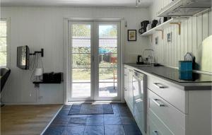 une cuisine avec une porte menant à une terrasse dans l'établissement 3 Bedroom Awesome Home In Nexø, à Strandby Gårde