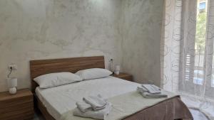 una camera da letto con un letto con asciugamani sopra di Adriano's Rooms a Catania