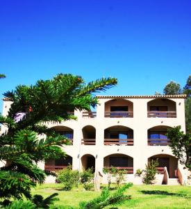 an apartment building with a palm tree in the foreground at Residence I Delfini in Tiuccia