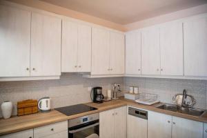 a kitchen with white cabinets and a sink at Betty's 4 Seasons in Agria in Agria