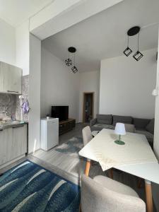una sala de estar con una mesa y un sofá en Apartman sm, en Herceg-Novi
