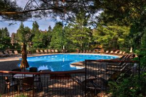 Una piscina con una mesa y sillas al lado. en Plateau A - Mont-Tremblant, en Mont-Tremblant