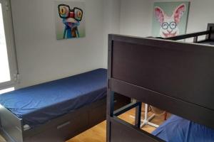 a bedroom with two bunk beds and a painting at Apartamento nuevo Playa aislada Primera línea de playa in Cullera