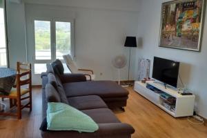 a living room with a couch and a tv at Apartamento nuevo Playa aislada Primera línea de playa in Cullera