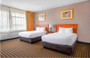 a hotel room with two beds and a window at Clarion Inn & Suites Miami International Airport in Miami