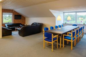 una sala de conferencias con mesa y sillas azules en Vedersø Klit Camping & Cottages, en Ulfborg