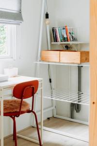 una scrivania con una sedia rossa accanto a una scrivania bianca di Boshuisje Lou op de Veluwe a Hattemerbroek